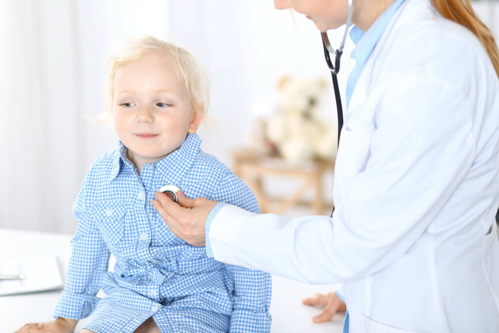 Doctor examining a little blonde girl with stethoscope.Medicine and healthcare concept.